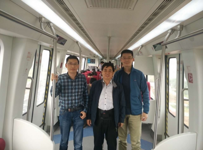 林国斌(中)与同事在长沙磁浮列车上) 林国斌(中)与同事在长沙磁浮列车上)
