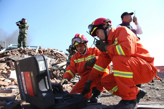 救援队利用蛇眼探测仪搜寻废墟中的生命迹象